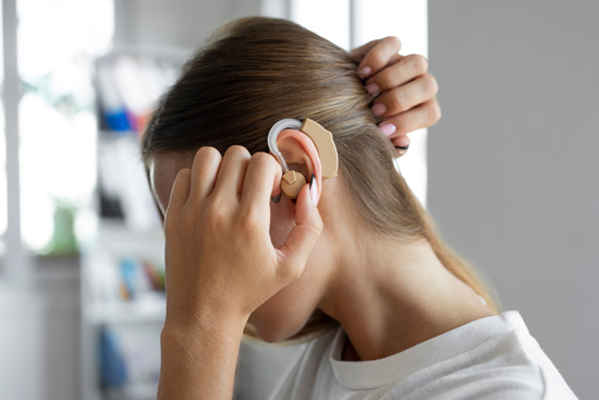 Femme apposant un appareil sur son oreille