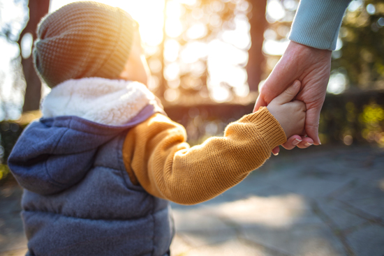 Parent avec son enfant, main dans la main