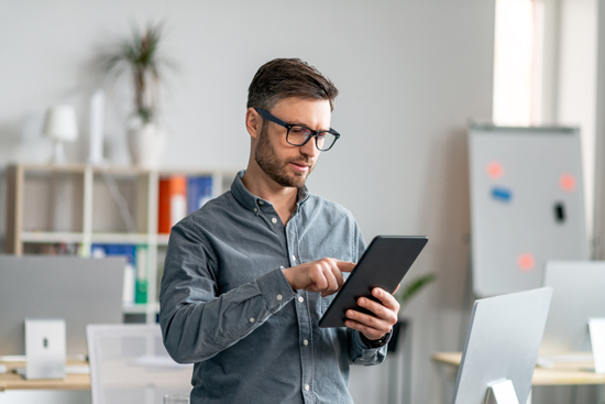 Homme tenant une tablette en main