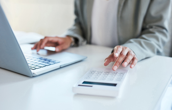 Femme devant un ordinateur utilisant une calculatrice