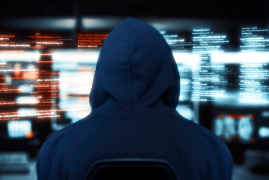 Pirate informatique, hacker devant écrans avec code informatique