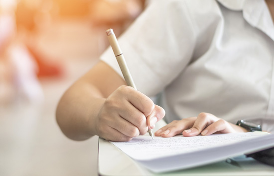 Femme écrivant avec un crayon