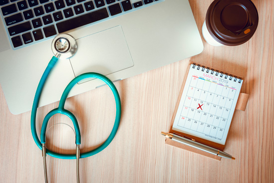 Calendrier, stéthoscope et ordinateur portable