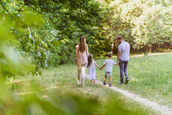 Famille marchant sur un sentier en lisière de forêt