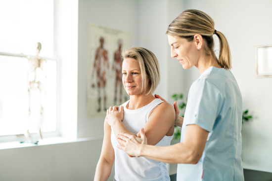 Femme kinésithérapeute ajustant la posture d'une personne